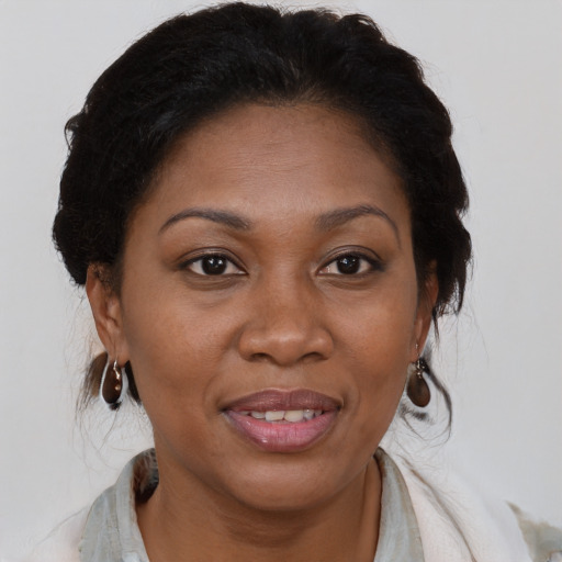 Joyful black adult female with medium  brown hair and brown eyes