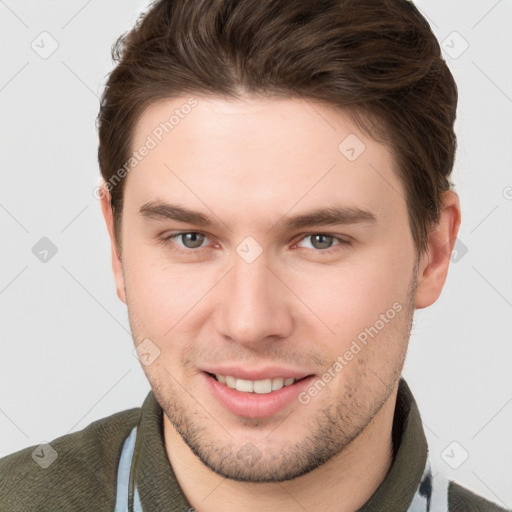 Joyful white young-adult male with short  brown hair and grey eyes