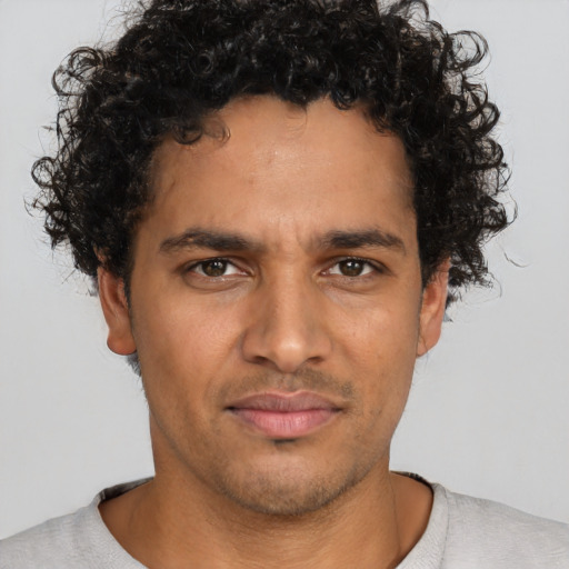 Joyful latino young-adult male with short  brown hair and brown eyes