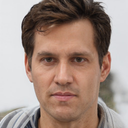 Joyful white adult male with short  brown hair and grey eyes