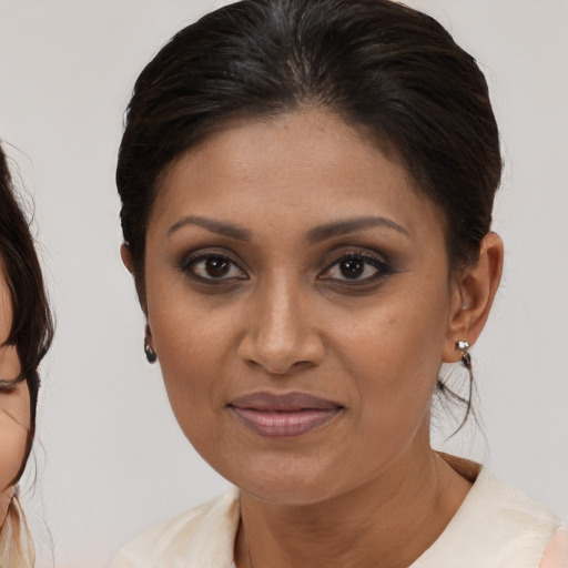 Joyful black adult female with medium  brown hair and brown eyes