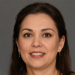 Joyful white adult female with long  brown hair and brown eyes