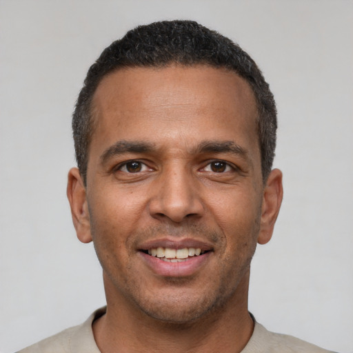 Joyful latino young-adult male with short  black hair and brown eyes