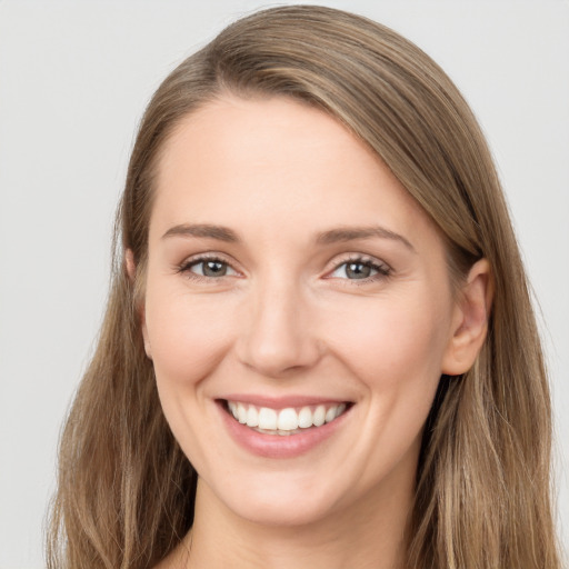 Joyful white young-adult female with long  brown hair and grey eyes