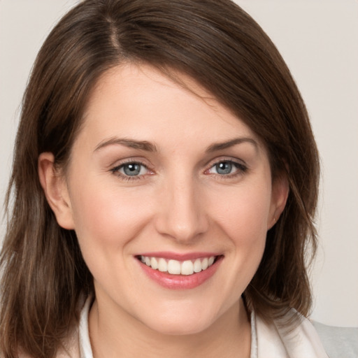 Joyful white young-adult female with medium  brown hair and grey eyes