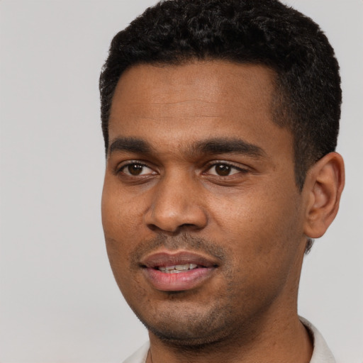 Joyful black young-adult male with short  black hair and brown eyes