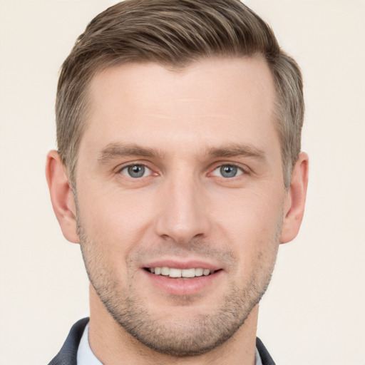 Joyful white young-adult male with short  brown hair and grey eyes