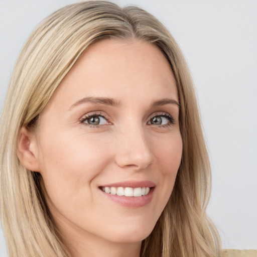 Joyful white young-adult female with long  brown hair and blue eyes