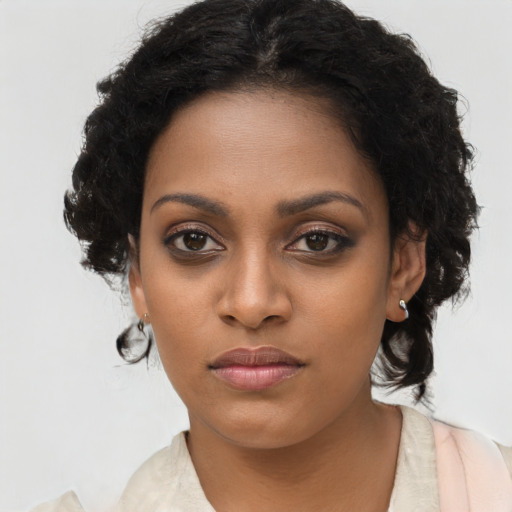 Joyful black young-adult female with long  brown hair and brown eyes