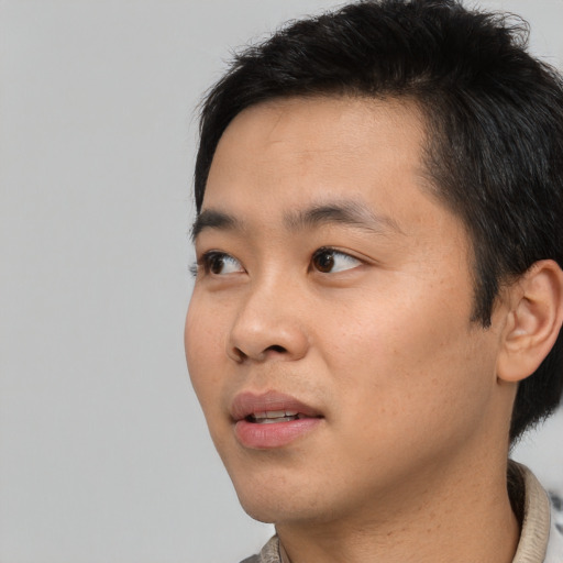 Joyful asian young-adult male with short  black hair and brown eyes