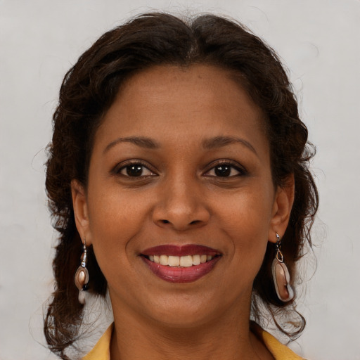 Joyful black young-adult female with long  brown hair and brown eyes