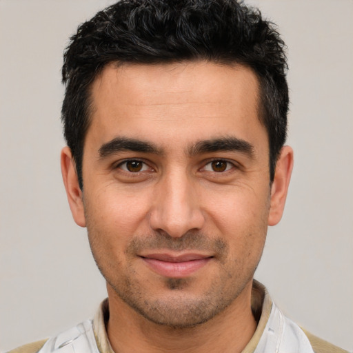 Joyful white young-adult male with short  black hair and brown eyes