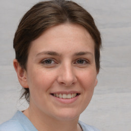 Joyful white young-adult female with medium  brown hair and grey eyes