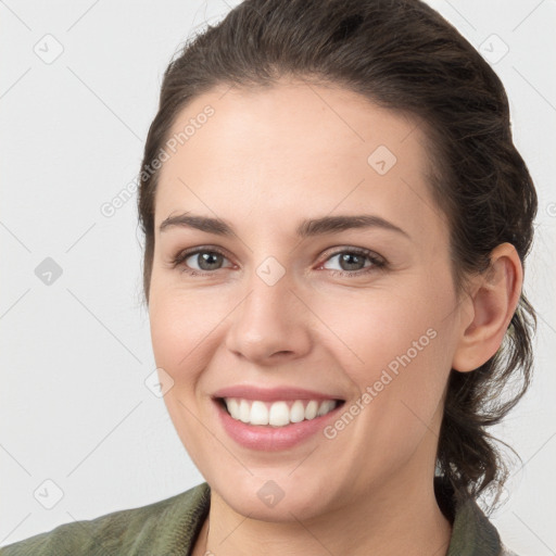 Joyful white young-adult female with medium  brown hair and grey eyes