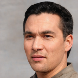 Joyful white adult male with short  black hair and brown eyes