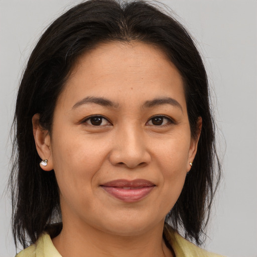 Joyful asian adult female with medium  brown hair and brown eyes