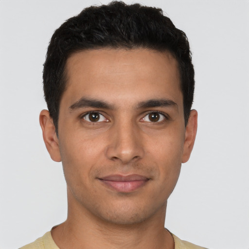 Joyful latino young-adult male with short  brown hair and brown eyes