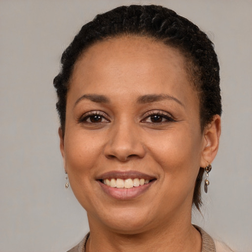 Joyful black young-adult female with short  brown hair and brown eyes