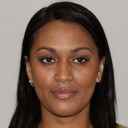Joyful black young-adult female with long  brown hair and brown eyes
