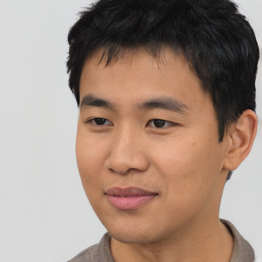 Joyful asian young-adult male with short  black hair and brown eyes