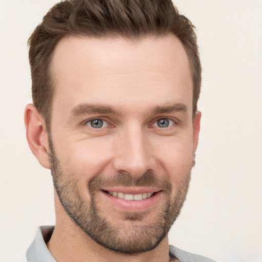 Joyful white young-adult male with short  brown hair and grey eyes