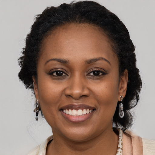 Joyful black young-adult female with long  brown hair and brown eyes