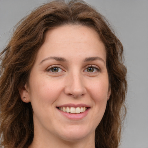 Joyful white young-adult female with long  brown hair and green eyes