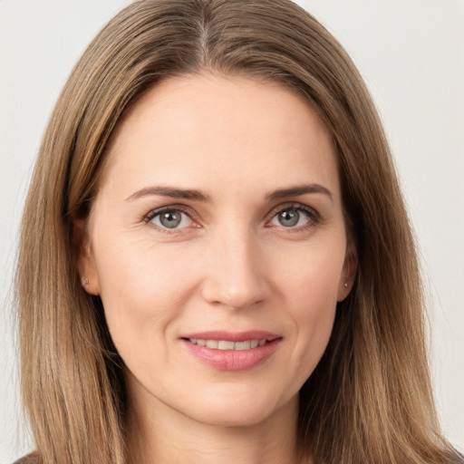 Joyful white young-adult female with long  brown hair and brown eyes