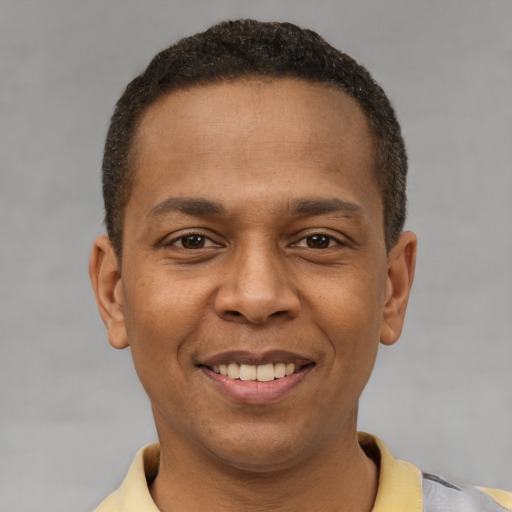 Joyful latino young-adult male with short  brown hair and brown eyes