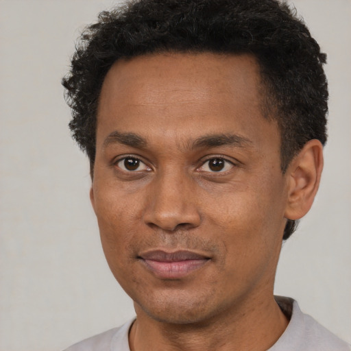 Joyful black adult male with short  black hair and brown eyes