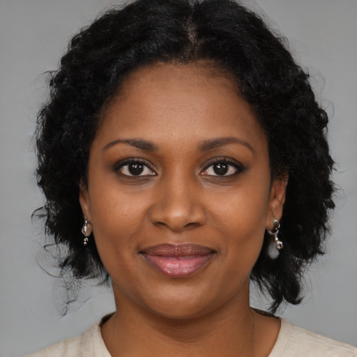 Joyful black young-adult female with medium  brown hair and brown eyes