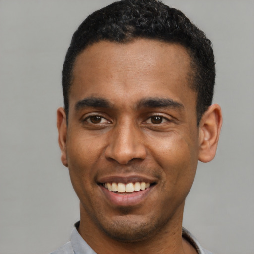 Joyful latino young-adult male with short  black hair and brown eyes