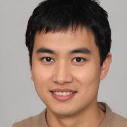 Joyful asian young-adult male with short  brown hair and brown eyes