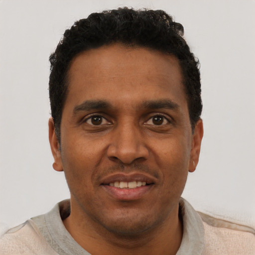 Joyful black young-adult male with short  black hair and brown eyes