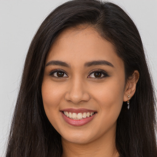 Joyful latino young-adult female with long  brown hair and brown eyes