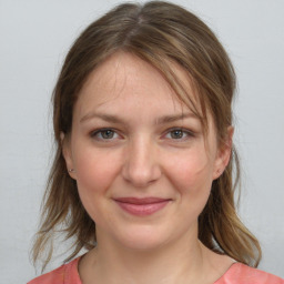 Joyful white young-adult female with medium  brown hair and grey eyes