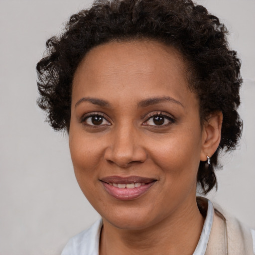 Joyful black young-adult female with short  brown hair and brown eyes