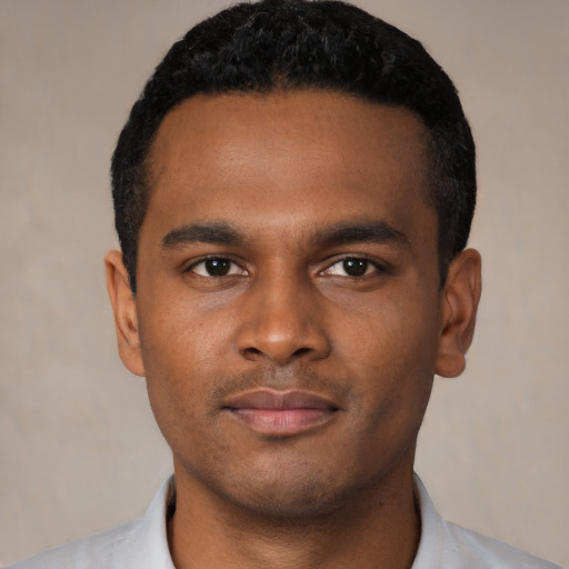 Joyful black young-adult male with short  black hair and brown eyes