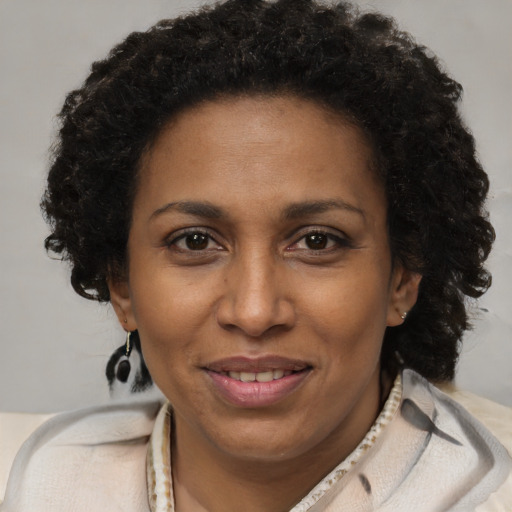 Joyful black adult female with short  brown hair and brown eyes