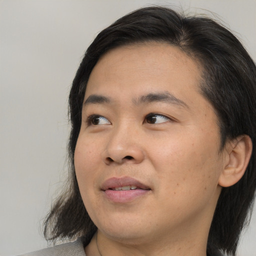 Joyful asian young-adult male with medium  black hair and brown eyes
