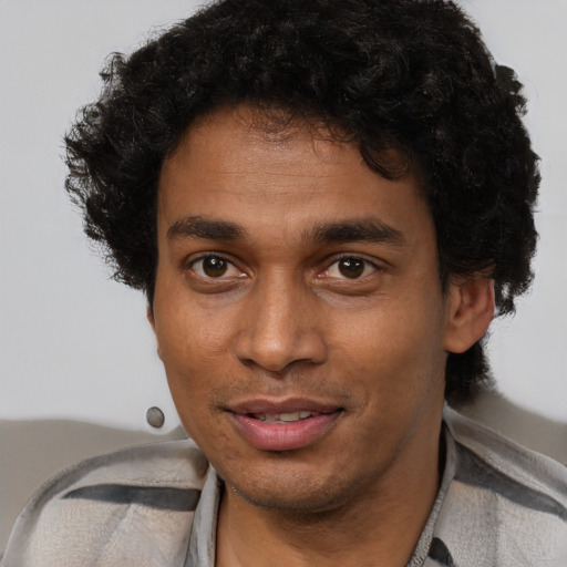 Joyful black young-adult male with short  brown hair and brown eyes