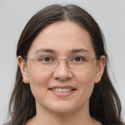 Joyful white adult female with long  brown hair and grey eyes