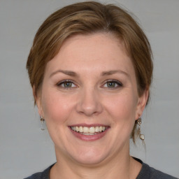 Joyful white adult female with medium  brown hair and grey eyes