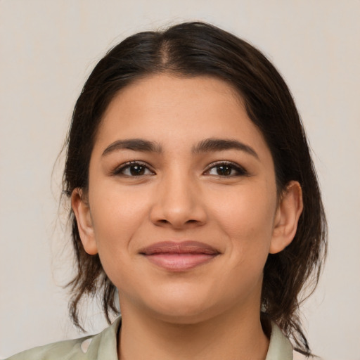 Joyful latino young-adult female with medium  brown hair and brown eyes