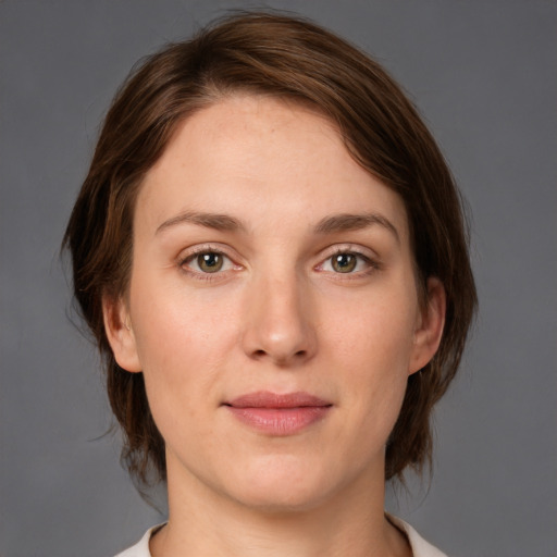 Joyful white young-adult female with medium  brown hair and green eyes