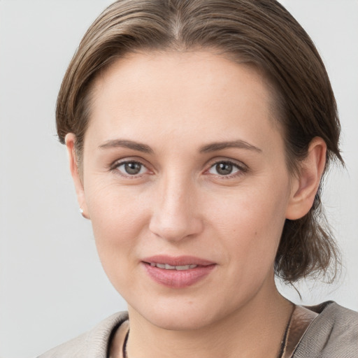 Joyful white young-adult female with medium  brown hair and grey eyes