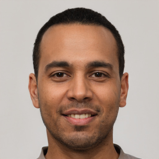 Joyful white young-adult male with short  black hair and brown eyes