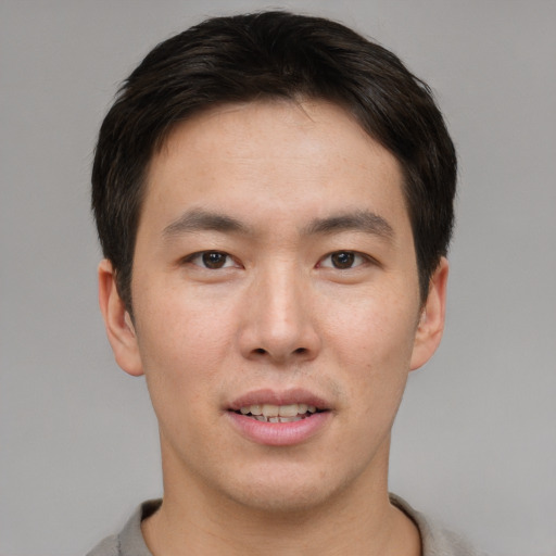Joyful asian young-adult male with short  brown hair and brown eyes
