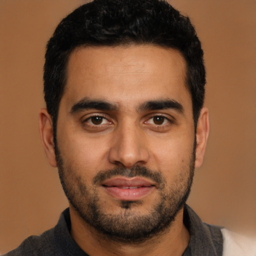 Joyful latino young-adult male with short  black hair and brown eyes
