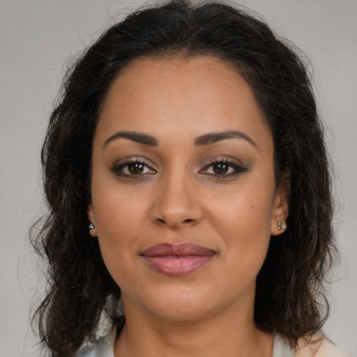 Joyful latino young-adult female with long  brown hair and brown eyes